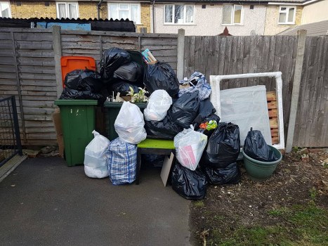 Staff managing commercial waste containers outside a Colindale business premises